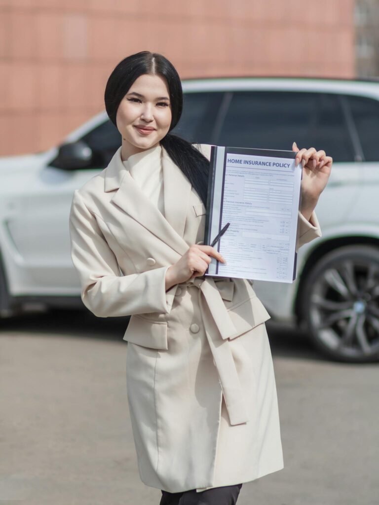 A Woman in Beige Trench Coat Holding an Insurance Policy while Standing on the Street